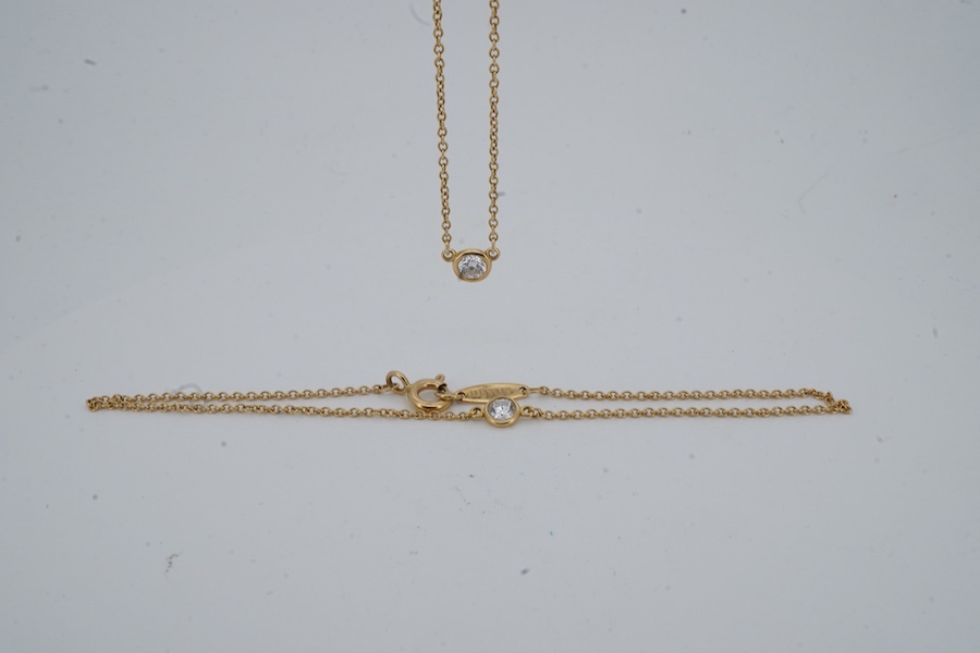 Elsa Peretti for Tiffany and Co., an 18ct gold and diamond 'Diamonds by the Yard' necklace and and bracelet, circa 2016, each composed of a spectacle-set brilliant-cut diamond weighing approximately 0.10 carats, to a fin